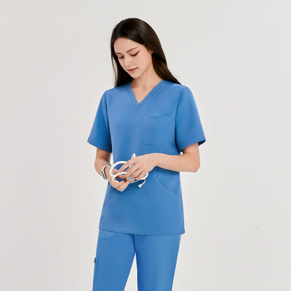 Woman wearing a sky blue scrub top and matching pants, holding a stethoscope, looking down,Sky Blue