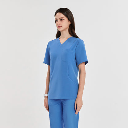 Woman wearing a sky blue scrub top and matching pants, standing in a half-side view, looking forward,Sky Blue