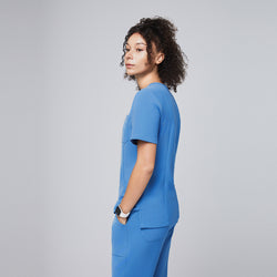 Image of Woman wearing a sky-blue scrub set viewed from the side, highlighting the streamlined fit and practical pocket placement of the professional uniform,Sky Blue