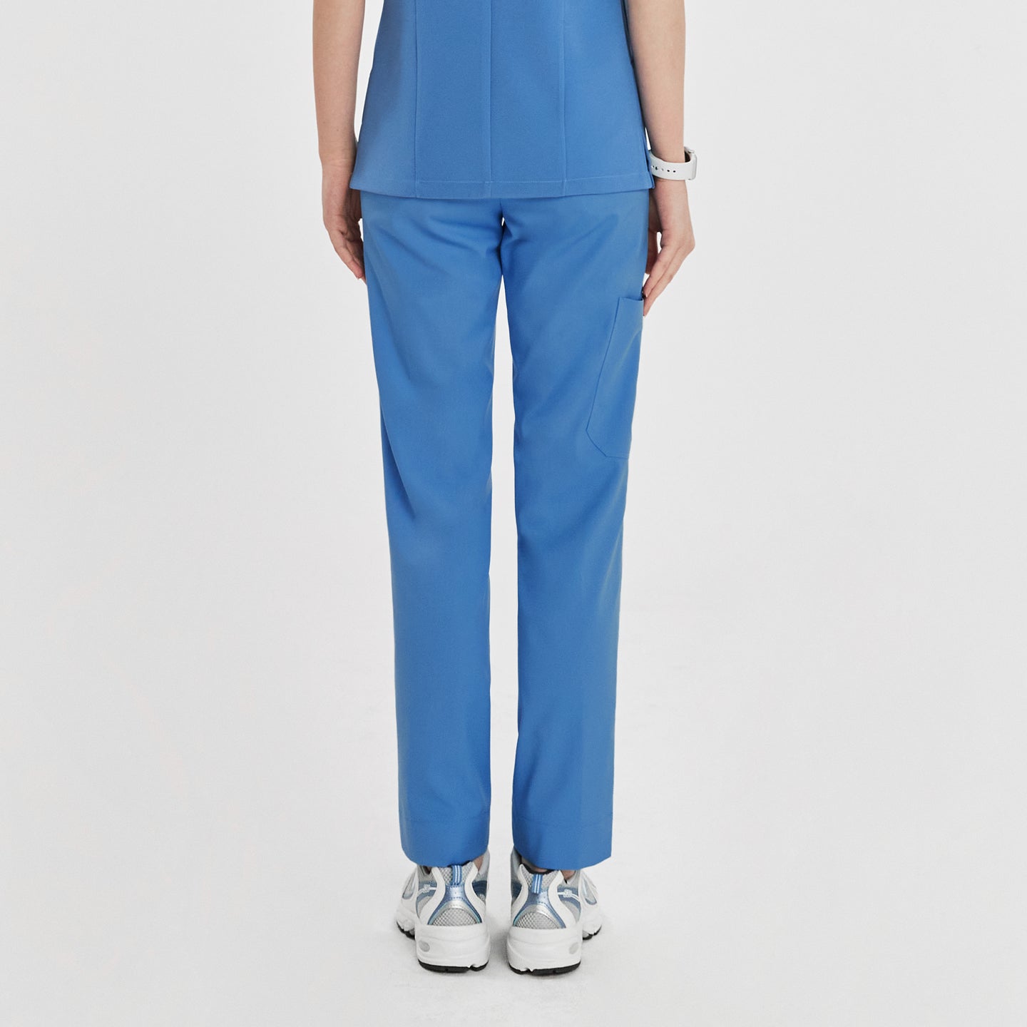 Woman in sky blue zipper slit scrub pants shown from the back, paired with a matching scrub top,Sky Blue