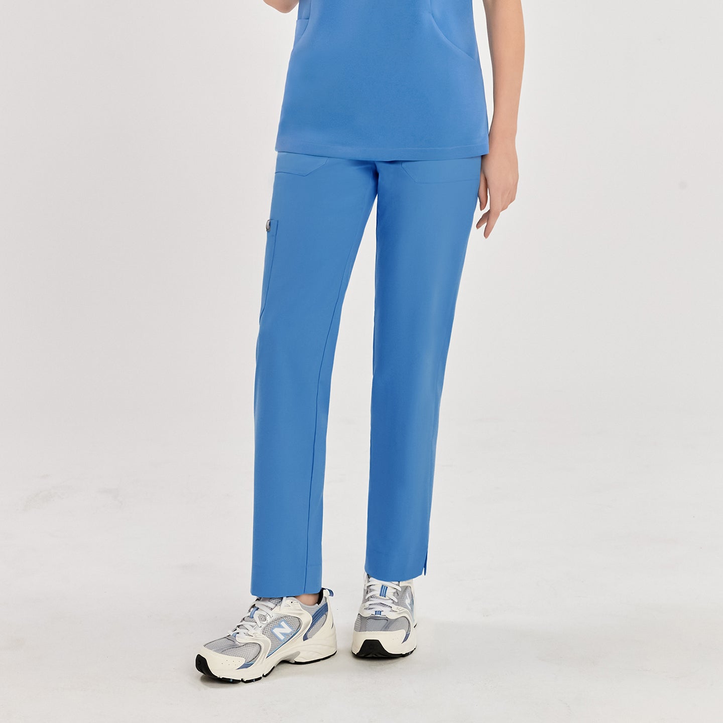 Woman in sky blue zipper slit scrub pants and matching top, showcasing the pants from the front,Sky Blue