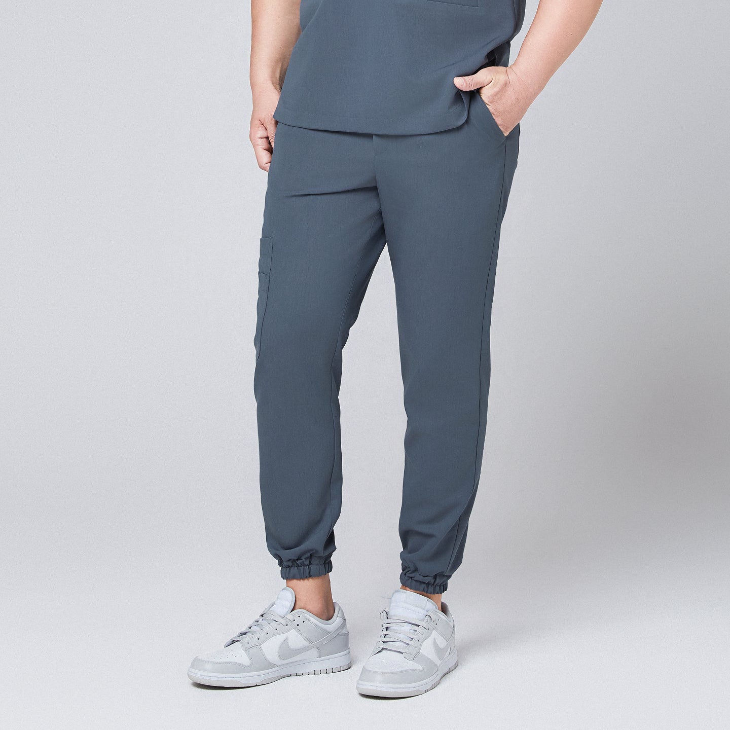 Smoky blue jogger scrub pants with elastic cuffs and side pockets, paired with gray Nike sneakers,Smoky Blue