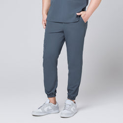 Image of Smoky blue jogger scrub pants with elastic cuffs and side pockets, paired with gray Nike sneakers,Smoky Blue