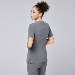 Image of Woman wearing Zenir soft gray front zipper scrub top, showing the back view, paired with matching pants,Ash Gray