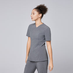 Image of Woman wearing Zenir soft gray front zipper scrub top with side profile, paired with matching pants,Ash Gray