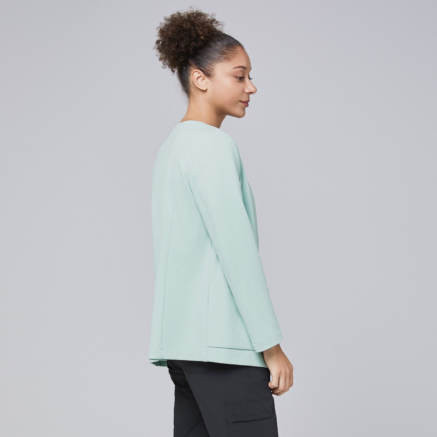 Side profile of a woman wearing a soft mint comfort cardigan paired with black scrub pants, highlighting the cardigan's clean and professional design,Soft Mint