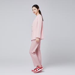 Image of A woman dressed in a soft pink comfort cardigan and matching trousers, paired with red and white sneakers, posing sideways against a plain background,Soft Pink