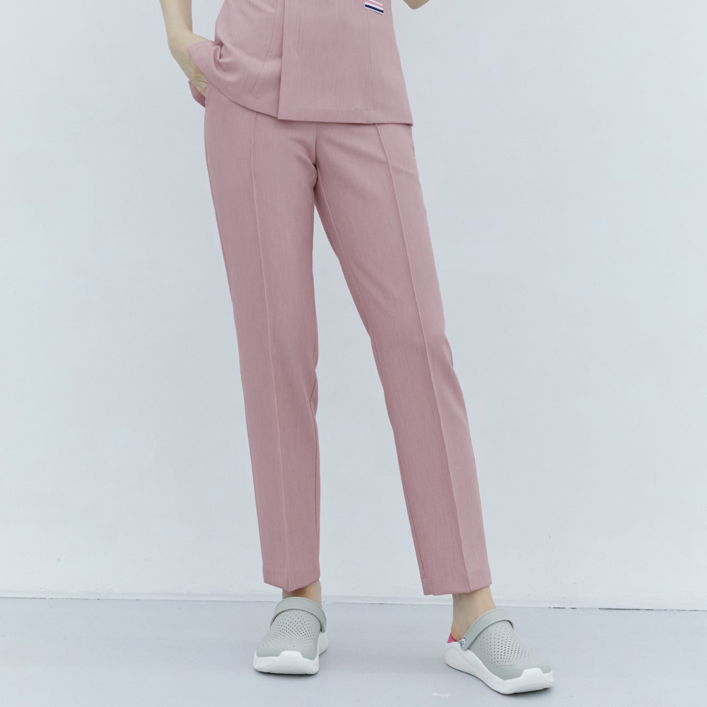  A woman wearing Soft Pink Line Banding Scrub Pants paired with gray shoes, showcasing the front view and fit of the pants,Soft Pink
