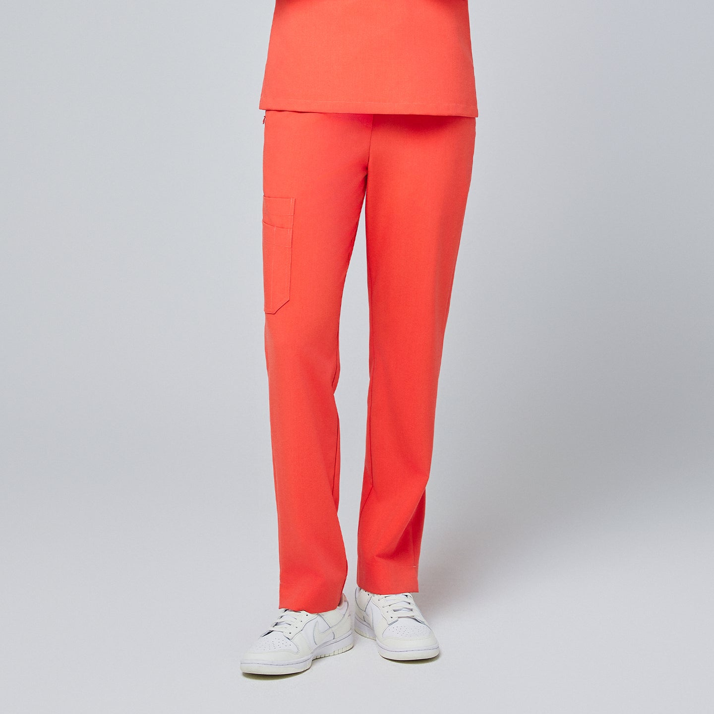 Bright tiger orange straight-leg scrub pants with a split hem and side cargo pocket, paired with white sneakers on a neutral background,Tiger Orange