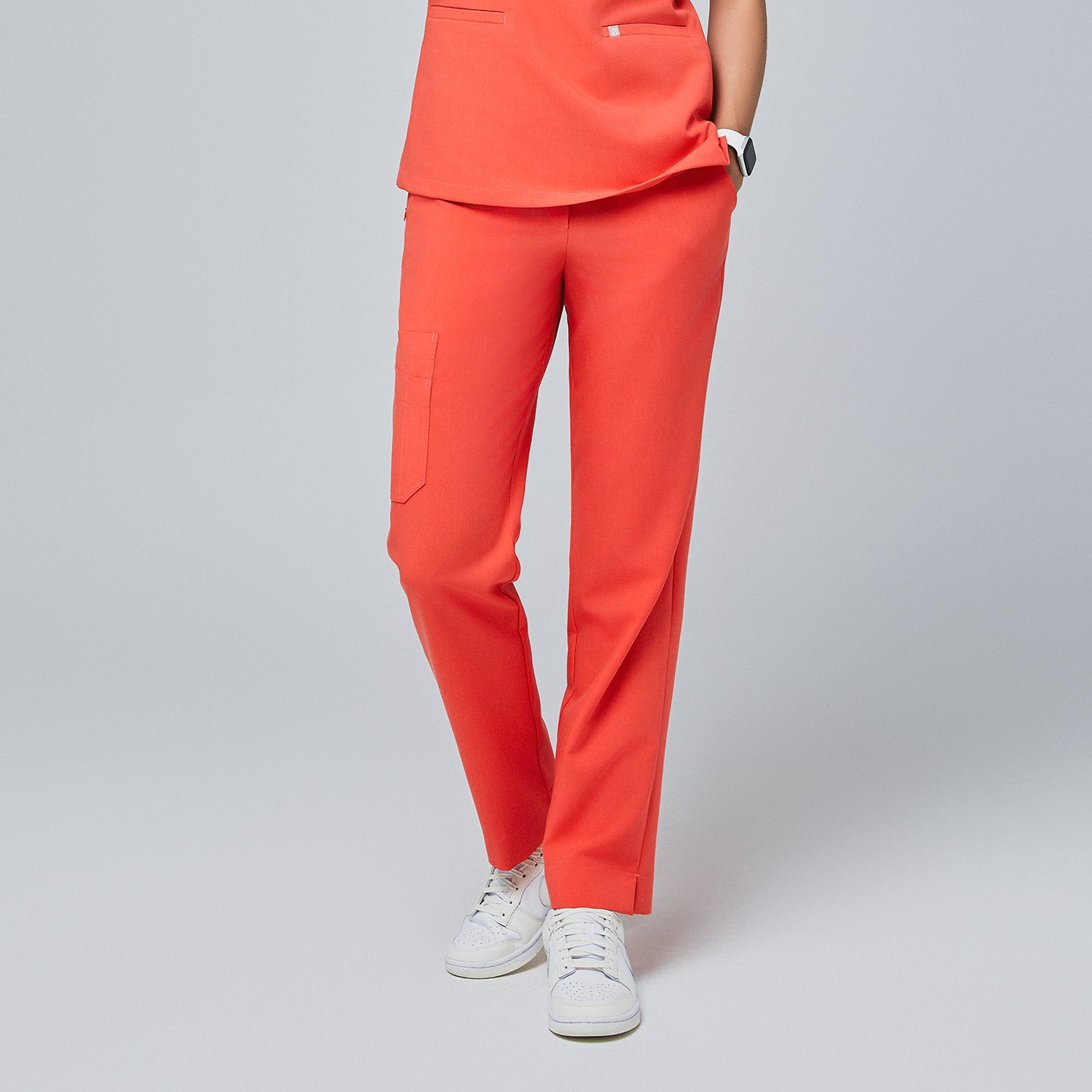 Front view of tiger orange straight-leg scrub pants with a split hem and cargo pocket, paired with white sneakers on a neutral background,Tiger Orange