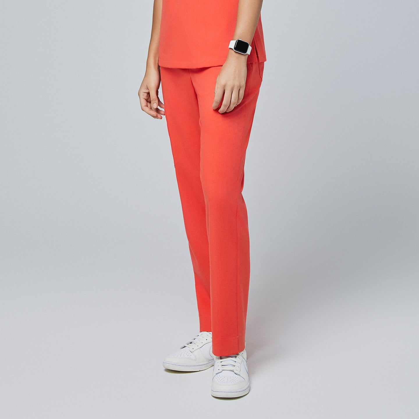 Close-up of tiger orange straight-leg scrub pants with a split hem, paired with white sneakers, highlighting the vibrant design,Tiger Orange