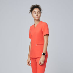 Image of A woman wearing a Tiger Orange Double Pocket Scrub Top and Tiger Orange Straight Split Hem Scrub Pants,Tiger Orange