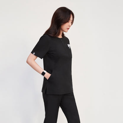 Zenir Scrub Top with face zipper, modeled by a woman holding items,Black