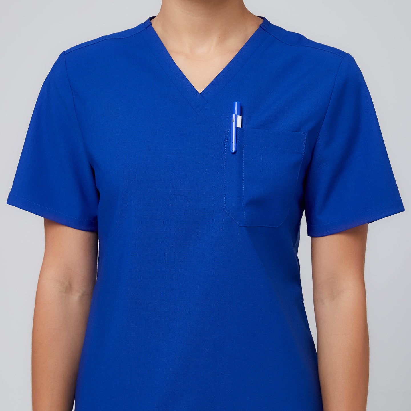 Close-up of Zenir royal blue 3-pocket scrub top with a pen in the chest pocket,Royal Blue