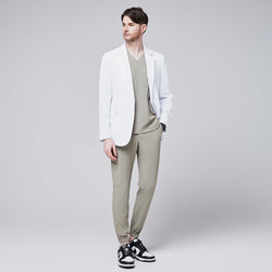 Image of Front view of a male model wearing a white short lab coat over olive green scrub pants, showcasing clean and tailored design,White