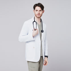 Image of Male model in a white short lab coat over an olive green scrub set, holding a stethoscope with a thoughtful expression,White