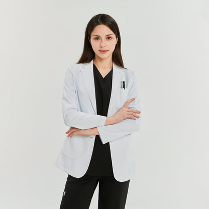 Woman wearing a white lab coat over a black scrub top and black pants, arms crossed, facing forward,White